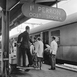 854146 Afbeelding van een stationsassistent met een elektrokar voor het vervoer van bagage bij een internationale trein ...